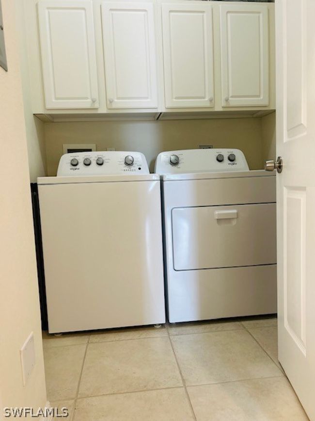 Clothes washing area with separate washer and dryer, cabinets, and light tile floors | Image 25
