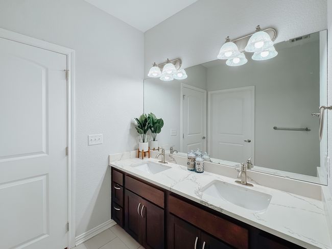 Primary bath with double sinks and updated countertops. | Image 15