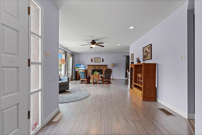 Living room featuring a ceiling fan, a fireplace, wood finished floors, and recessed lighting | Image 12