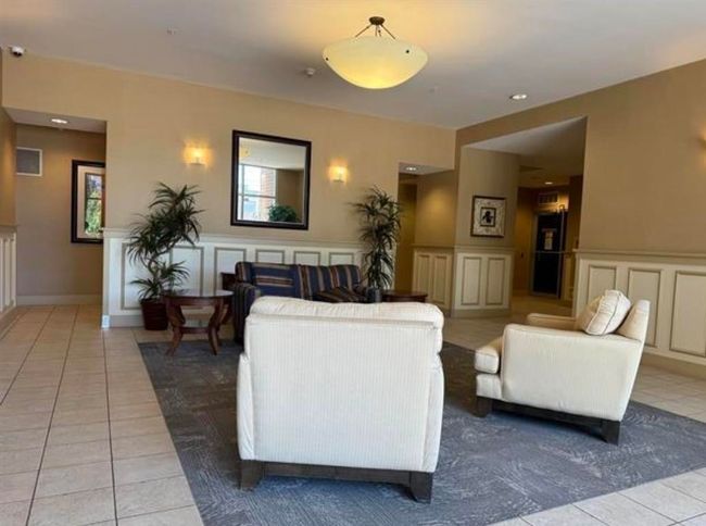 Living room featuring a decorative wall and light tile patterned floors | Image 6