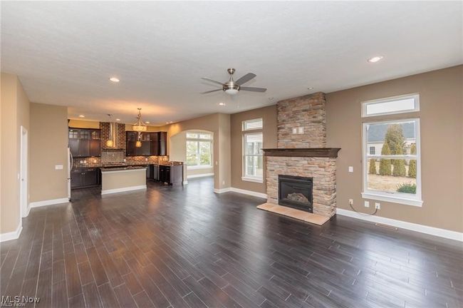 Unfurnished living room with a fireplace, dark wood-type flooring, ceiling fan, and baseboards | Image 15