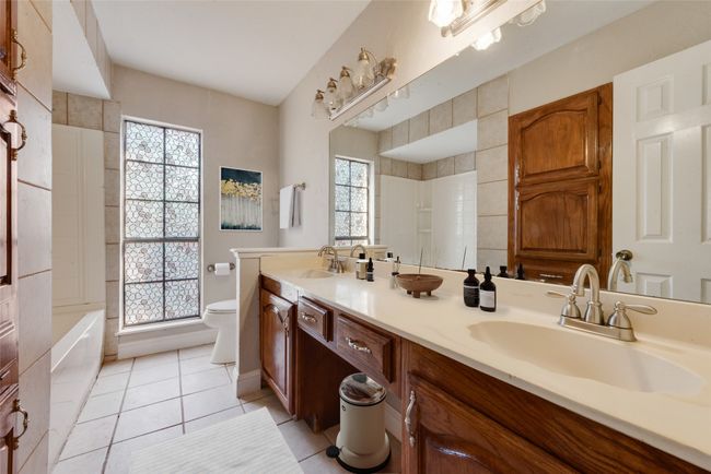 Full bathroom featuring double vanity, plenty of natural light, and tile patterned floors | Image 9