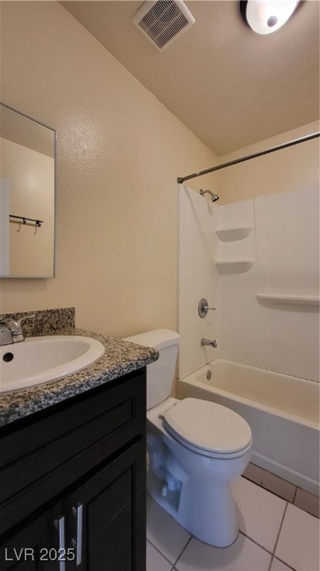 Bathroom featuring toilet, tile patterned floors, visible vents, and vanity | Image 8
