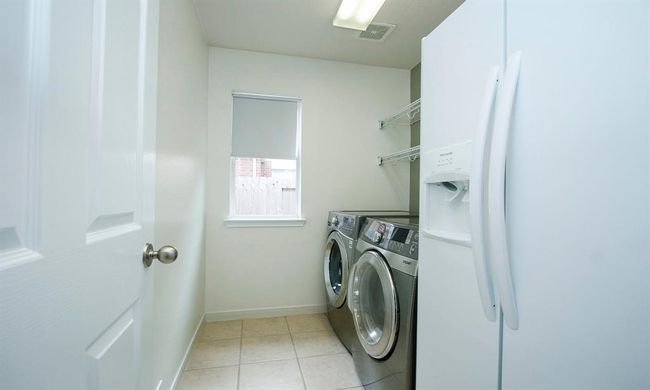 Utility room offers a washer, dryer, refrigerator and plenty of space for those everyday laundry needs! | Image 16