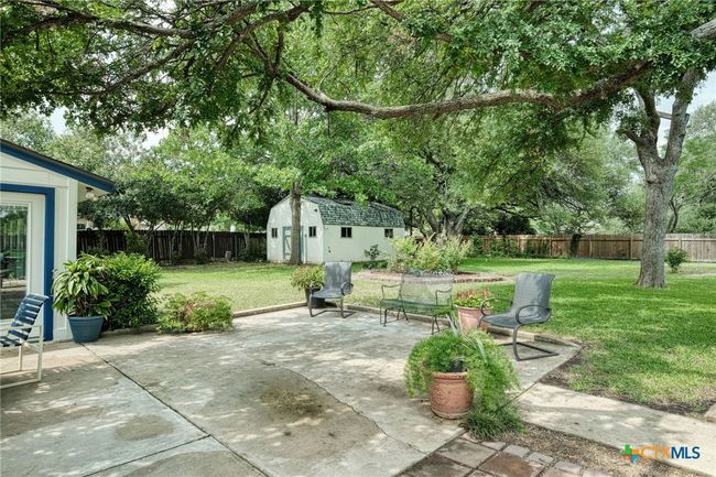 Another view of the extended patio and the other side of this almost 1/2 acre lot. Notice the oversized workshop/storage shed that has a window unit AC and is wired for electricity. | Image 28