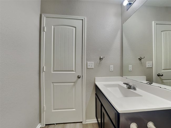 Bathroom with vanity, a textured wall, and wood finished floors | Image 14