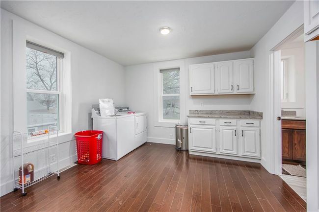 Laundry room with washer and dryer, cabinet space, dark wood-type flooring, and plenty of natural light | Image 42