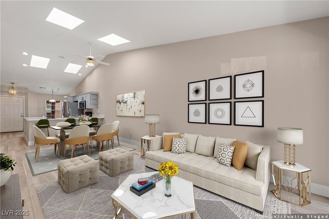 Living area featuring light wood-style floors, high vaulted ceiling, ceiling fan, a skylight, and recessed lighting | Image 8