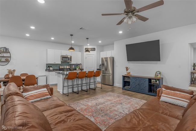 Living area featuring light wood-style floors, visible vents, a ceiling fan, and recessed lighting | Image 7