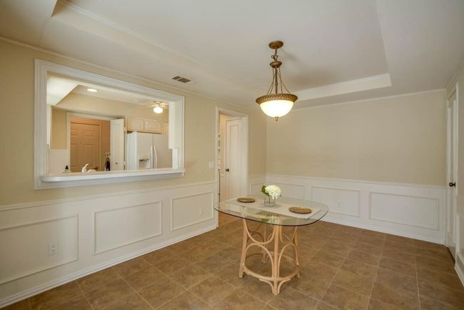 Dining room with a decorative wall, ornamental molding, and a raised ceiling | Image 12