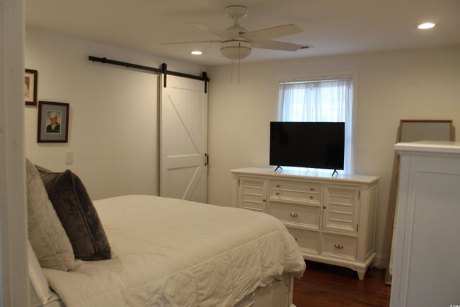 Bedroom with recessed lighting, a barn door, dark wood finished floors, and ceiling fan | Image 9