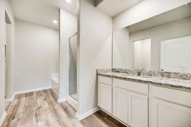 Bathroom featuring baseboards, recessed lighting, wood finished floors, a shower stall, and vanity | Image 7