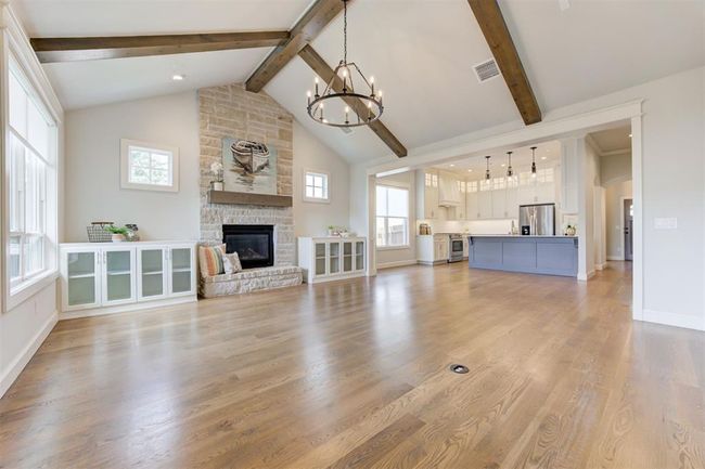 Living room with vaulted ceiling, built ins, plenty of windows with natural light and wood beams. | Image 5