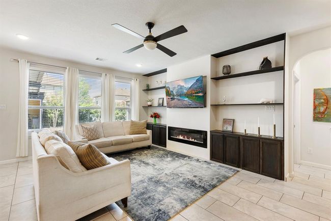 This gorgeous living room features modern finishes, custom built-in shelving, and a sleek fireplace. | Image 19