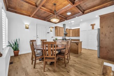 Dining area with a healthy amount of sunlight, wooden ceiling, light hardwood / wood-style floors, coffered ceiling, and beam ceiling | Image 2