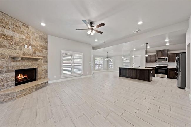 Open family room with wood burning fireplace. | Image 5
