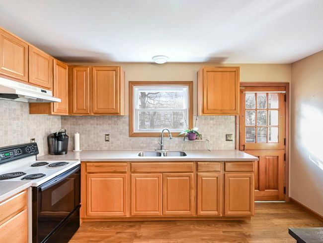 Kitchen featuring white range with electric cooktop, tasteful backsplash, sink, and light hardwood / wood-style flooring | Image 5