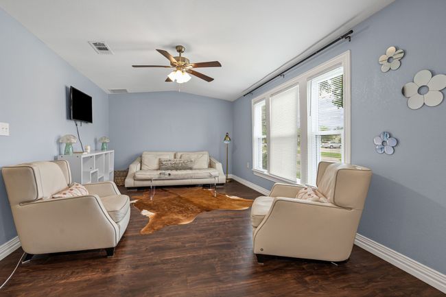 Living room with ceiling fan, wood finished floors, and vaulted ceiling | Image 7