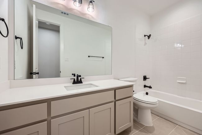 Bathroom with toilet, shower / bathtub combination, vanity, visible vents, and tile patterned floors | Image 22
