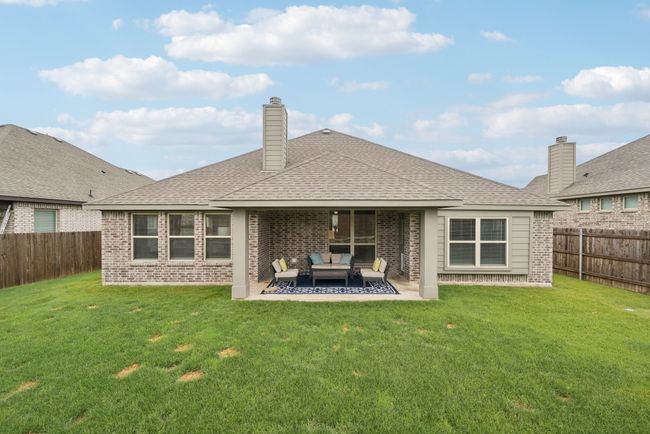 Back of property with outdoor lounge area, brick siding, a patio area, and roof with shingles | Image 36