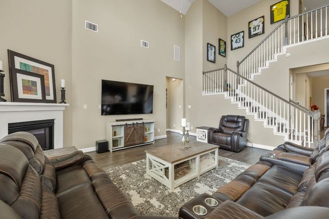 Living room with view of the open staircase and hall to primary bedroom | Image 13