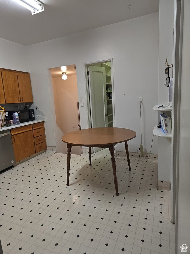 Kitchen featuring light countertops, brown cabinets, dishwasher, and black microwave | Image 22