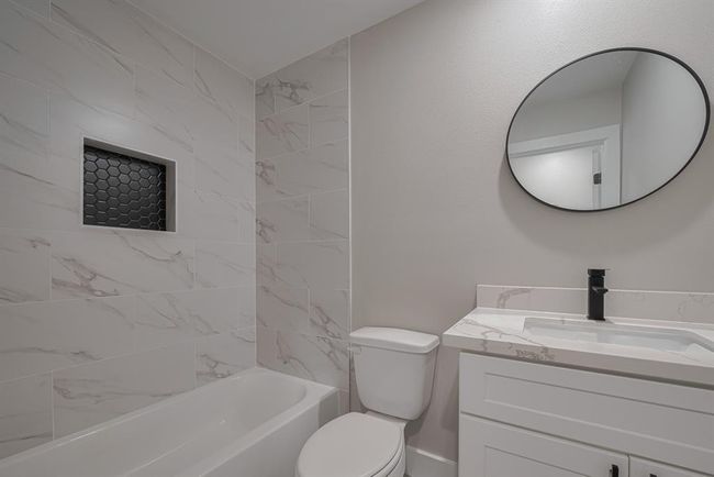 Thoughtfully designed second bath includes a sleek vanity with storage below, coordinating finishes, and a tub-shower combo that blends function and clean style. | Image 24