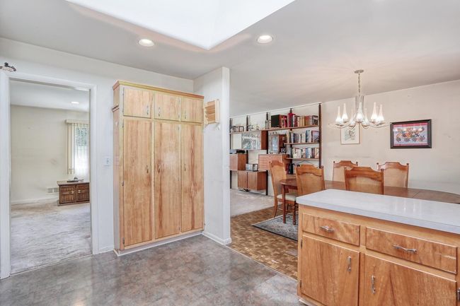 Kitchen featuring light countertops, pendant lighting, a notable chandelier, and recessed lighting | Image 12