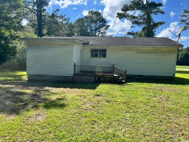 Rear view of property with a wooden deck, crawl space, and a yard | Image 15