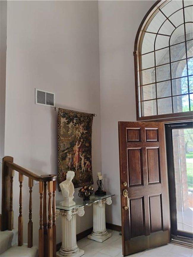 Foyer featuring a towering ceiling, baseboards, visible vents, and light tile patterned floors | Image 14
