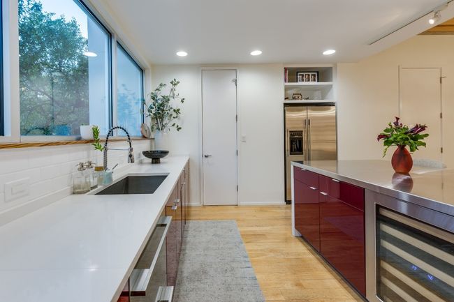 Kitchen featuring dishwasher, sink, wine cooler, stainless steel fridge with ice dispenser, and light wood-type flooring | Image 18