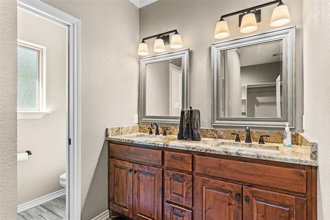 Bathroom featuring dual sinks, toilet, and large vanity | Image 10