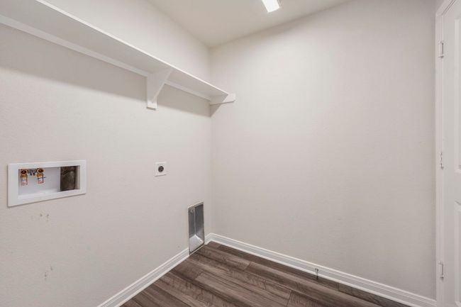 Full-size laundry room with shelving and conveniently located with access to hall and garage. | Image 19