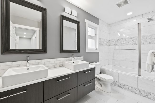 Bathroom with a sink, visible vents, toilet, and tiled shower / bath | Image 25