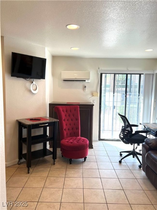 Living room with recessed lighting, baseboards, a textured ceiling, light tile patterned flooring, and a wall mounted air conditioner | Image 11