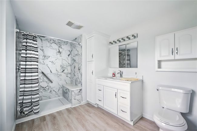 Beautifully updated 1st floor bathroom w/ step in shower & seat. | Image 7