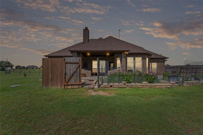 Back of house featuring brick siding, a chimney, and a shingled roof | Image 21