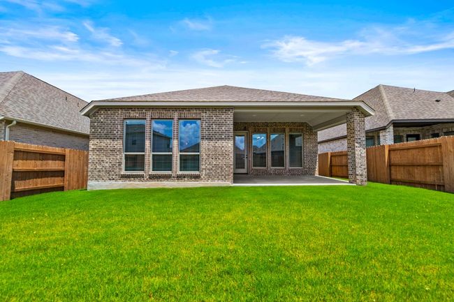 Rear view of property with brick siding, a patio, a fenced backyard, and roof with shingles | Image 25