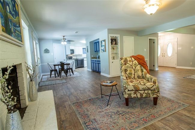 View from fireplace toward breakfast area and kitchen beyond. French doors to the right open to the full-width front porch. | Image 16