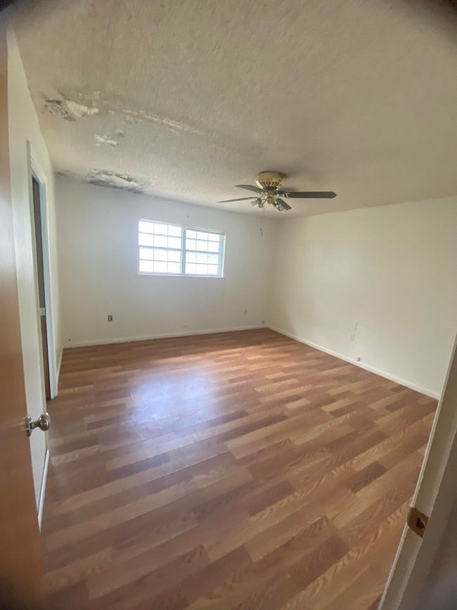 Spare room with a textured ceiling, wood finished floors, and a ceiling fan | Image 6