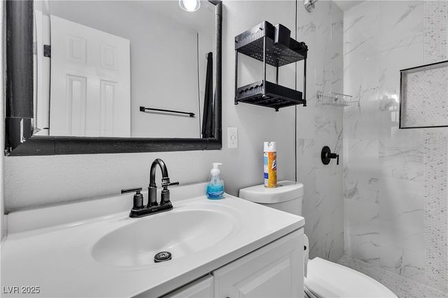 Bathroom featuring toilet, a marble finish shower, and vanity | Image 36