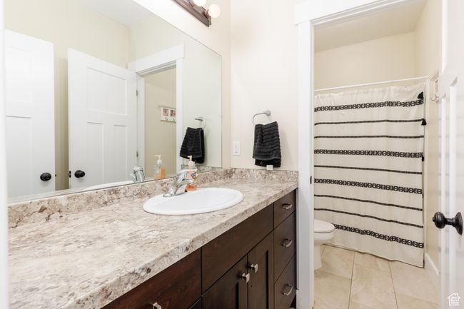 Bathroom with vanity, tile patterned flooring, and a shower with shower curtain | Image 33