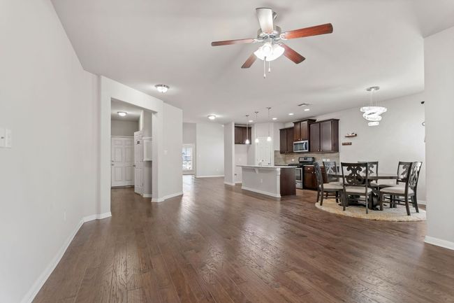 Living area featuring baseboards, ceiling fan, and dark wood-style flooring | Image 14