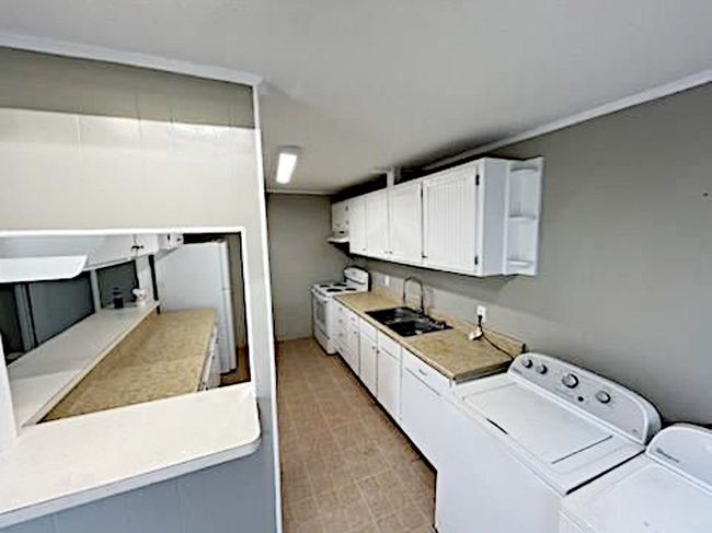 Kitchen has stove, fridge, and included washer and dryer | Image 10