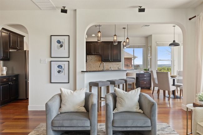 Living area featuring arched walkways and dark wood-style flooring | Image 4