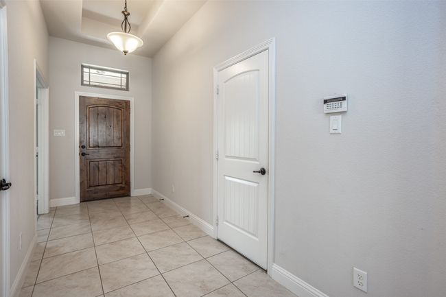 Foyer entrance featuring light tile patterned flooring and a tray ceiling | Image 6