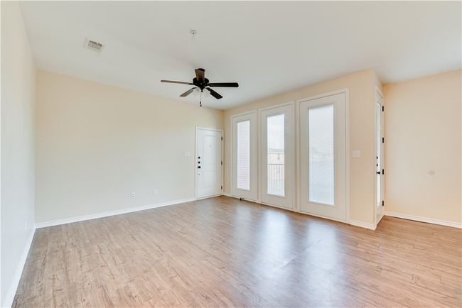Empty room featuring ceiling fan, baseboards, visible vents, and light wood-style flooring | Image 7
