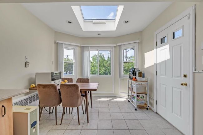 Dining room with healthy amount of natural light, light tile patterned flooring, a skylight, and recessed lighting | Image 7