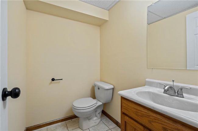 Bathroom with tile patterned floors, toilet, baseboards, and vanity | Image 35