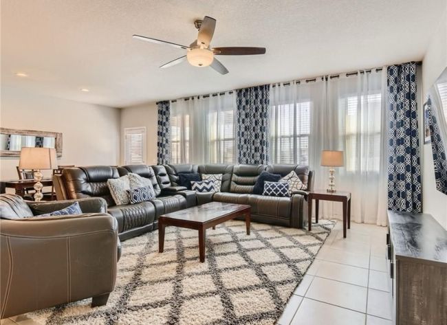 Living area featuring light tile patterned floors and ceiling fan | Image 15